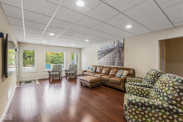 living room with a paneled ceiling and dark hardwood / wood-style flooring