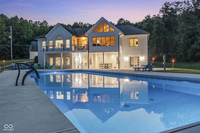 pool at dusk featuring a patio area