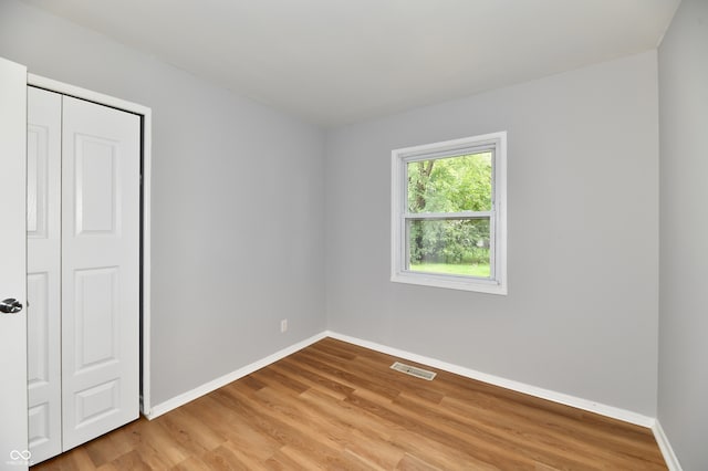 unfurnished bedroom with a closet and hardwood / wood-style floors