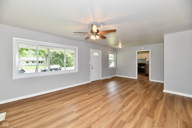 unfurnished living room featuring ceiling fan and light wood-type flooring