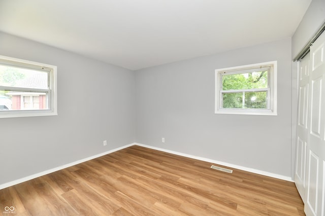 unfurnished room with hardwood / wood-style flooring