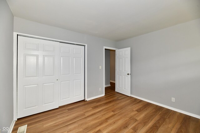 unfurnished bedroom with a closet and hardwood / wood-style floors