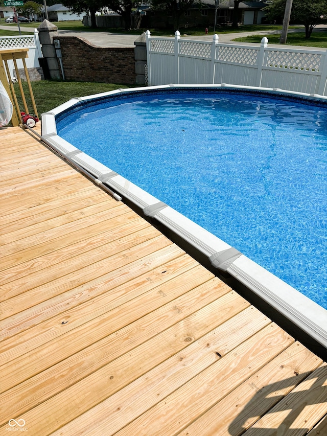 outdoor pool featuring fence and a wooden deck