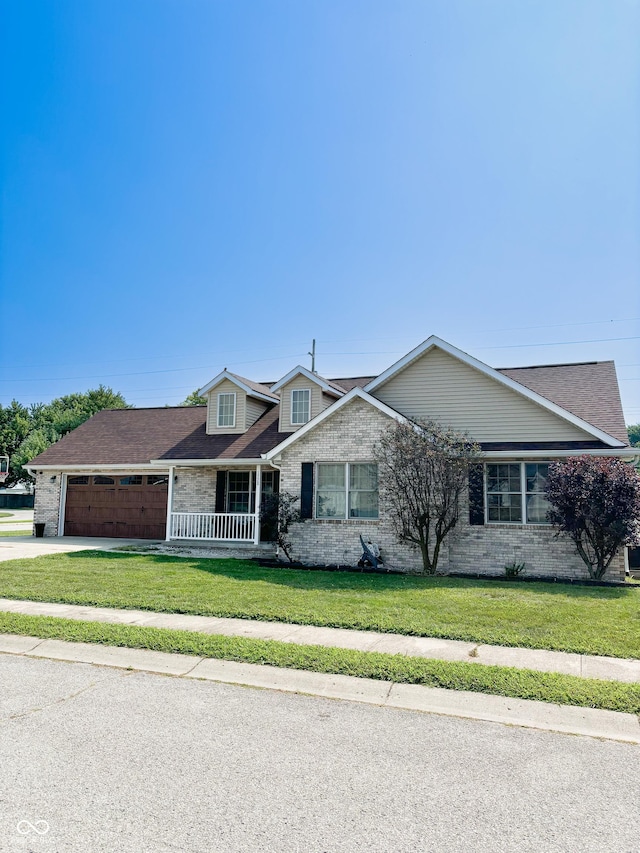 view of front of home featuring a garage, driveway, brick siding, and a front yard