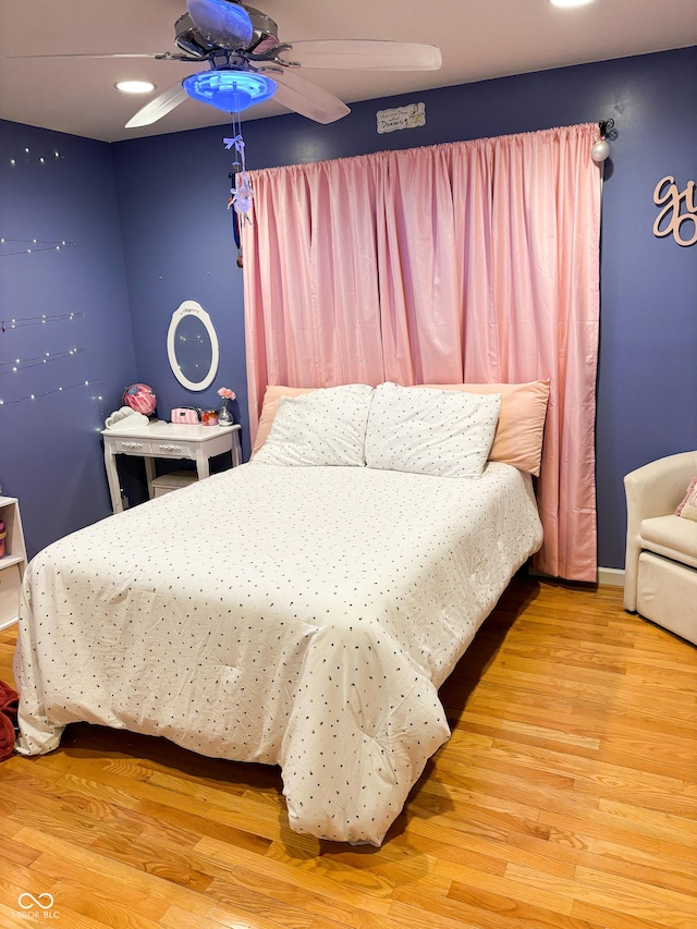 bedroom with a ceiling fan, baseboards, and wood finished floors