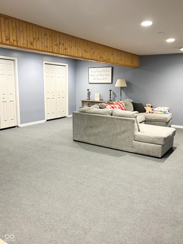 living area featuring recessed lighting, wood walls, carpet, and baseboards