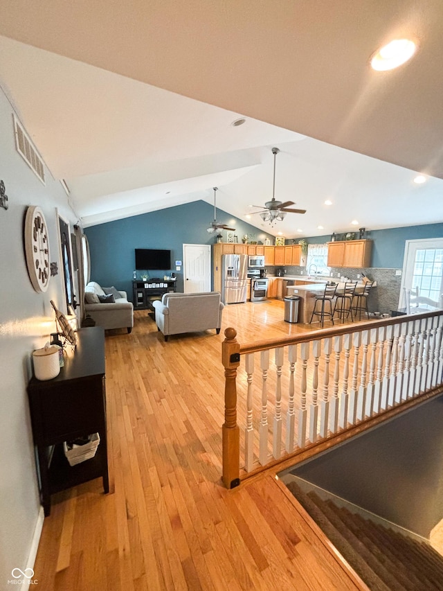 living area with recessed lighting, visible vents, light wood-style flooring, a ceiling fan, and vaulted ceiling