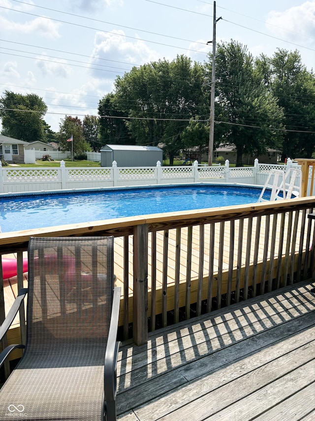 outdoor pool featuring an outbuilding and fence