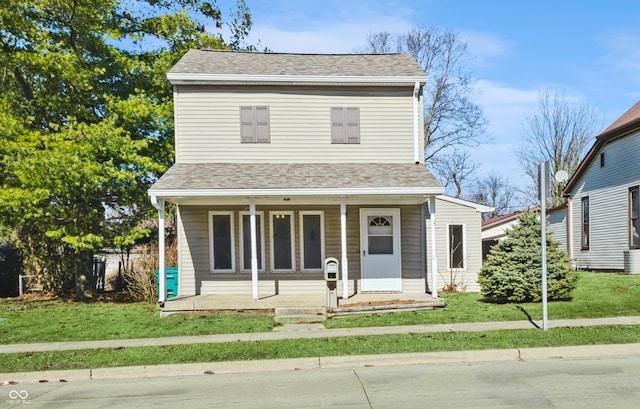 view of front of property with central air condition unit, a front yard, and covered porch