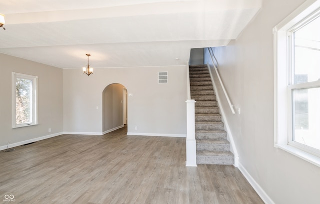 stairway with a notable chandelier and wood-type flooring