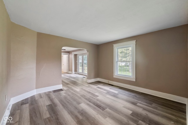 empty room with french doors and light hardwood / wood-style floors