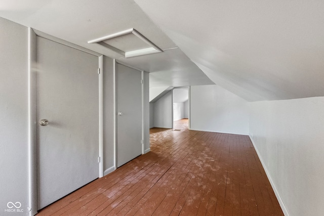 additional living space featuring hardwood / wood-style floors and vaulted ceiling