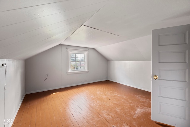 additional living space with light wood-type flooring and lofted ceiling