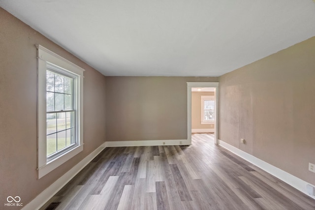 unfurnished room featuring light wood-type flooring and a wealth of natural light