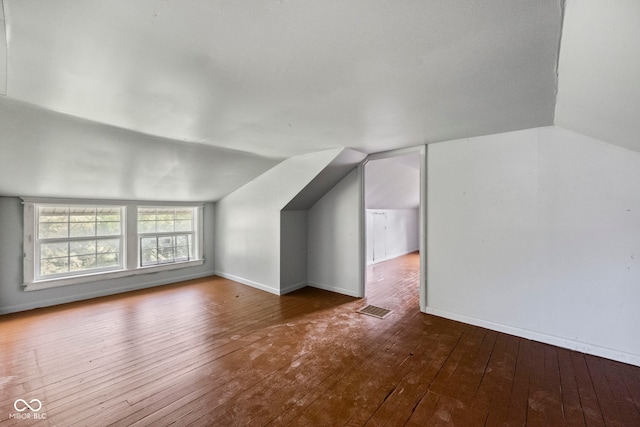 bonus room with wood-type flooring and vaulted ceiling