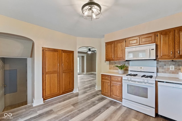 kitchen featuring decorative backsplash, light hardwood / wood-style floors, ceiling fan, and white appliances