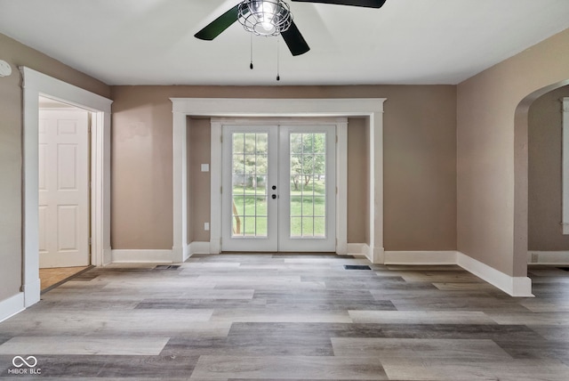 entryway with light hardwood / wood-style floors, ceiling fan, and french doors