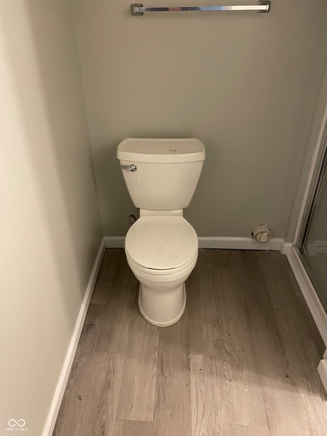 bathroom featuring wood-type flooring and toilet