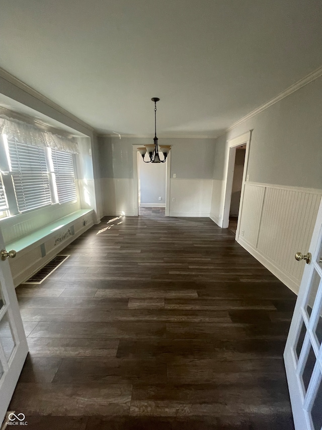 interior space featuring ornamental molding, an inviting chandelier, and dark wood-type flooring