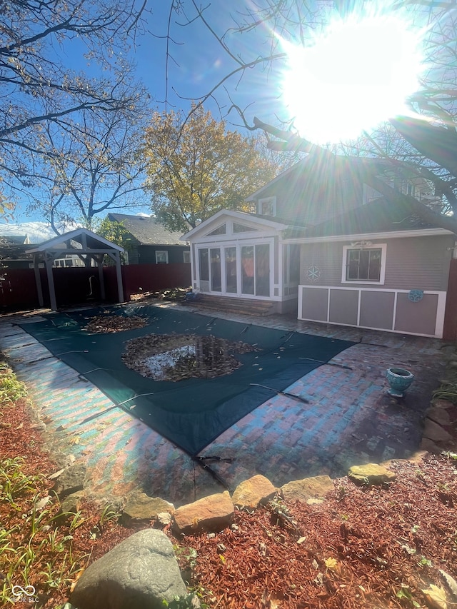 view of swimming pool featuring a gazebo, a sunroom, and a patio