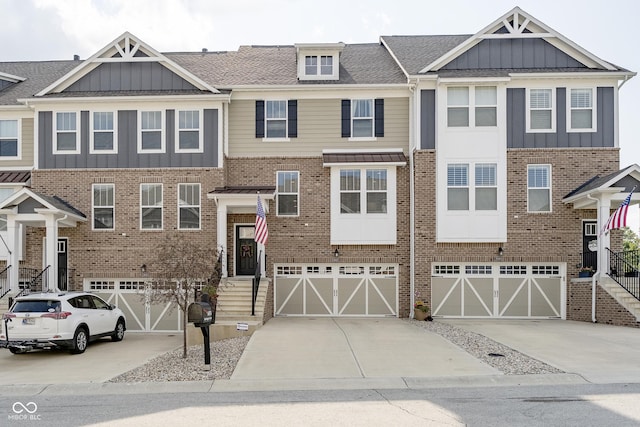 view of front facade featuring board and batten siding, concrete driveway, brick siding, and an attached garage