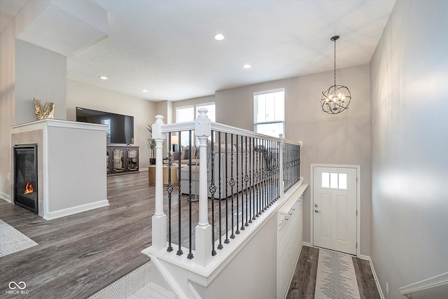 corridor with an inviting chandelier and dark hardwood / wood-style floors