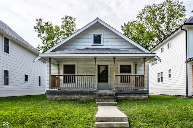 bungalow-style home with covered porch and a front lawn