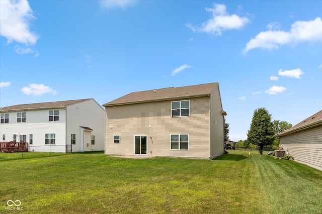 rear view of property featuring cooling unit and a yard