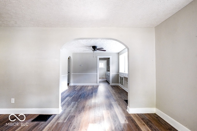 corridor with dark wood-type flooring and a textured ceiling