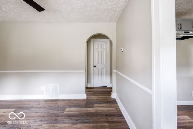 corridor featuring a textured ceiling and dark wood-type flooring