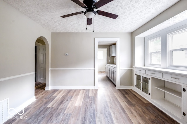 spare room featuring light hardwood / wood-style flooring, a textured ceiling, and ceiling fan