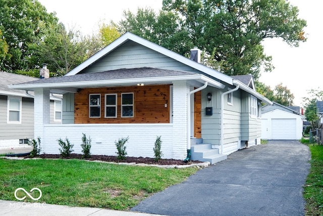 view of front of house featuring a front yard, an outbuilding, and a garage