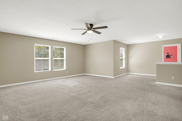 carpeted spare room with ceiling fan and a textured ceiling