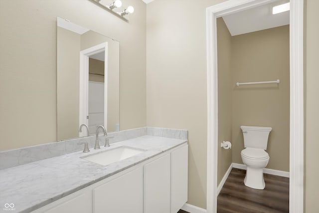 bathroom with wood-type flooring, toilet, and vanity