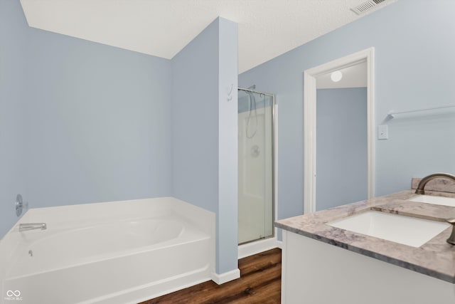 bathroom with vanity, hardwood / wood-style floors, and shower with separate bathtub