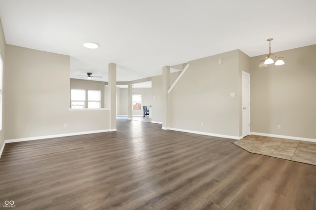 unfurnished living room with dark hardwood / wood-style floors and ceiling fan with notable chandelier