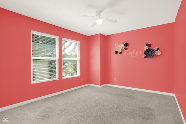 spare room featuring ceiling fan and carpet