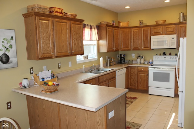 kitchen featuring sink, white appliances, kitchen peninsula, and light tile patterned floors