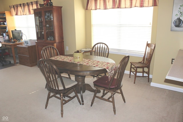 dining area with plenty of natural light and light carpet