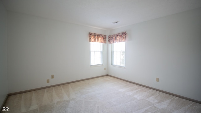 empty room featuring light carpet, baseboards, and visible vents