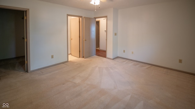 unfurnished bedroom featuring a walk in closet and light colored carpet