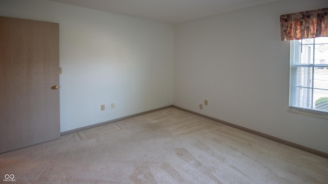 empty room featuring light carpet and baseboards