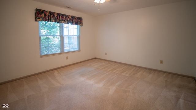 empty room featuring light colored carpet and ceiling fan