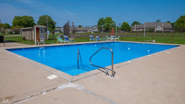 pool with fence, a lawn, and a patio