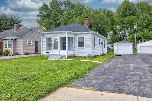 view of front facade with a garage, an outdoor structure, and a front lawn