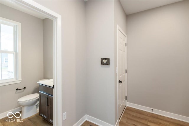 bathroom featuring toilet, vanity, and hardwood / wood-style flooring