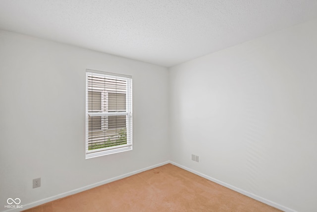 carpeted empty room featuring a textured ceiling