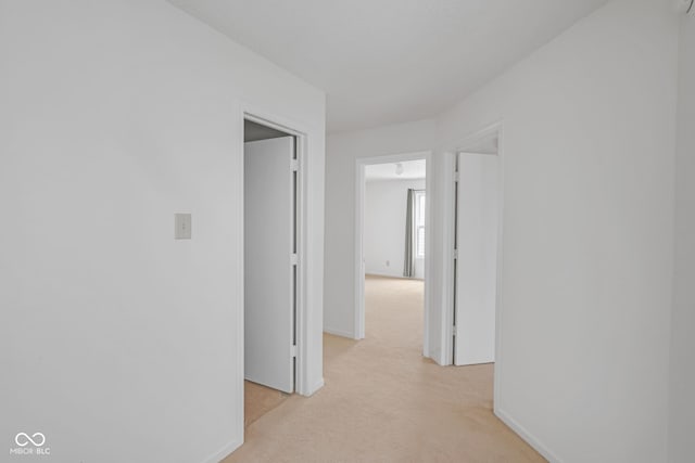 hallway featuring light colored carpet