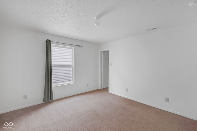 carpeted spare room with a textured ceiling