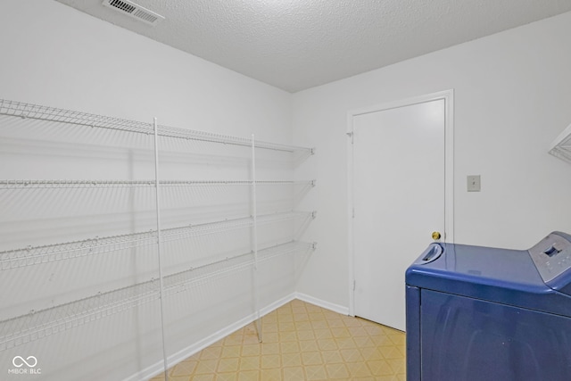 laundry room with washer / dryer and a textured ceiling